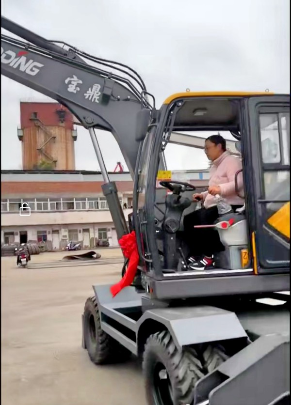 女士開(kāi)寶鼎輪式挖掘機(jī)